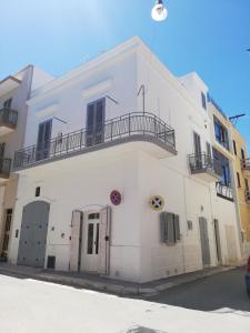 ポリニャーノ・ア・マーレにあるPortoncino46の白い建物の横にバルコニーがあります。