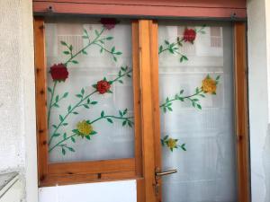 a glass door with flowers on a curtain at Il Nido del Gabbiano - Riviera Adriatica in Martinsicuro