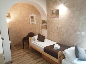 ein kleines Zimmer mit 2 Betten und einem Stuhl in der Unterkunft Apartament i pokoje gościnne Gniezno in Gniezno