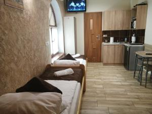 a living room with three beds and a kitchen at Apartament i pokoje gościnne Gniezno in Gniezno +18 photos