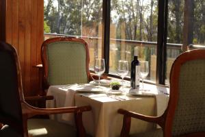 a table with two chairs and a table with wine glasses at Hotel Lastra in Puebla