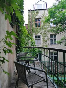 a balcony with two chairs and a building at Prestige location apartments Pijarska street in Krakow