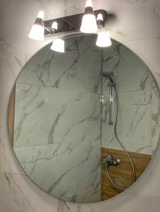 a bathroom with a large mirror with a shower at Petite Luxury Urban House in Tríkala