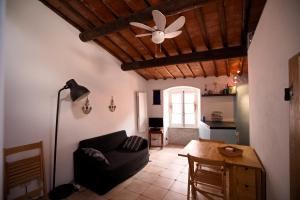 sala de estar con sofá y ventilador de techo en Borgo Antico - La Mansarde, en Tellaro