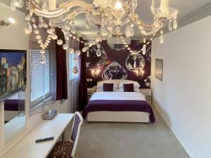 a bedroom with a bed and a chandelier at Shangri La Mansion in Mostar