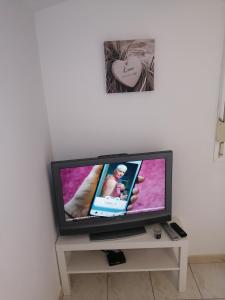 a flat screen tv sitting on a table in a room at studio refait a neuf avec la fibre in Vaugneray