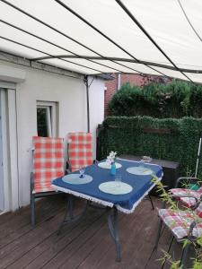 einen Tisch und Stühle auf einer Terrasse unter einem Baldachin in der Unterkunft Haus Hölderlin in Wilhelmshaven