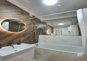 un bagno con un lavandino bianco e uno specchio di New Lux apartment 2022 a Charkiv Altre 11 foto
