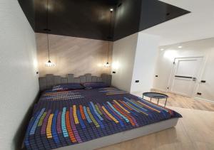 una camera da letto con un grande letto con una coperta colorata di New Lux apartment 2022 a Charkiv
