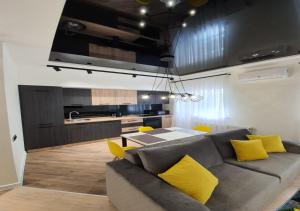 a living room with a gray couch and yellow pillows at New Lux apartment 2020 in Kharkiv