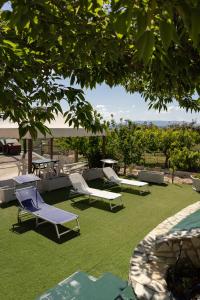 a patio with chairs and tables on the grass at Camagna Country House in Santa Ninfa