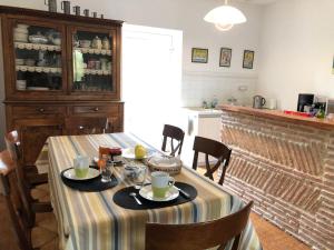 uma sala de jantar com uma mesa e uma cozinha em Chambres d’hôtes de Pouzatel em Fumel