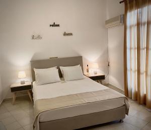 a bedroom with a large bed with two tables and two lamps at Asteri Hotel in Livadi
