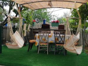 uma mesa e cadeiras com redes de descanso num jardim em Vivenda Soares em Fátima