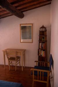 un comedor con una mesa y un estante de libros en Borgo Antico - La Mansarde, en Tellaro