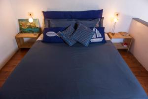 1 dormitorio con cama azul y almohadas azules en Borgo Antico - La Mansarde, en Tellaro