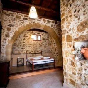 a bedroom with a bed in a stone wall at Luxurious Stone Apartment 1 in Rókka