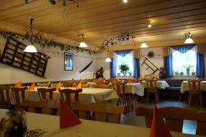 a dining room with tables and chairs and windows at Gasthof Pension Waldfrieden in Brand