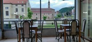 a table and chairs on a balcony with a view at Rio Hotel in Prizren