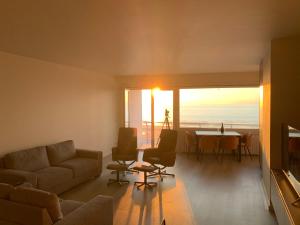 a living room with a couch and a table at Parel aan het strand in Ostend