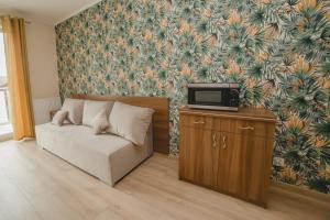 een woonkamer met een bank en een tv bij Willa Mirella in Dębki