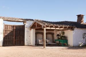 an old house with a green table in front of it at Caserio Aldeallana in Segovia