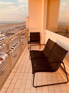 een balkon met een stoel en uitzicht op het strand bij Parel aan het strand in Oostende