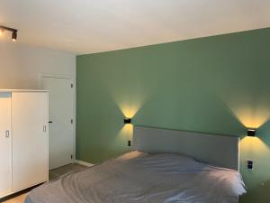een slaapkamer met een bed en twee lampen aan de muur bij Parel aan het strand in Oostende