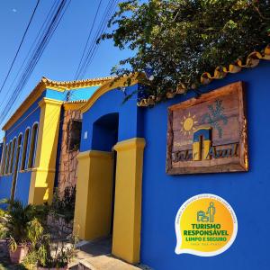 un bâtiment bleu et jaune avec un panneau sur lequel figure un panneau dans l'établissement Pousada Solar Azul, à Lençóis