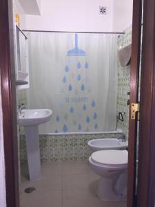 a bathroom with a sink and a toilet and a shower curtain at Over the Rainbow in Almada
