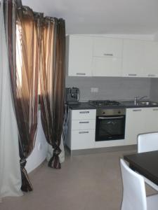a kitchen with a stove and curtains in a room at Casa Malù in Pula +14 photos