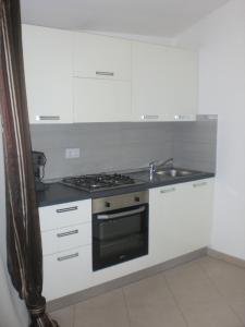 a kitchen with white cabinets and a stove top oven at Casa Malù in Pula