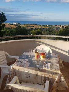 een tafel met wijnglazen op het balkon bij Appartamento La finestra sul mare in Madonna della Pace