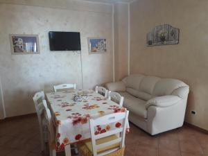 een woonkamer met een tafel en een bank bij Residence Rosa in Margherita di Savoia