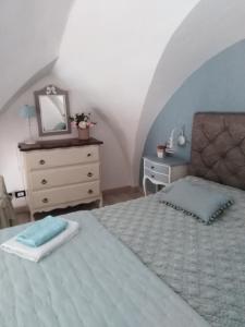 sypialnia z łóżkiem, komodą i lustrem w obiekcie La chiave di Philoxenia w mieście Ostuni