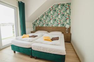 twee bedden in een kamer met een groene muur bij Willa Mirella in Dębki +52 foto's
