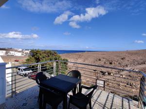 una mesa en un balcón con vistas a la playa en Apartamento Playa Quemada Lanzarote, en Playa Quemada