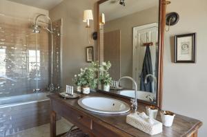 uma casa de banho com um lavatório e um espelho grande em Hotel Caserio Aldeallana em Segóvia