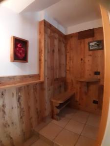 a room with a wooden wall with a bench in it at Appartamento 3cime Stefania in Padola