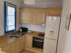 a kitchen with wooden cabinets and a white refrigerator at Finiki Villas in Foinikion +26 photos