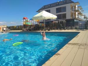 una persona in una piscina con frisbee di Apartamenty Przystanek Plaża Sarbinowo a Sarbinowo