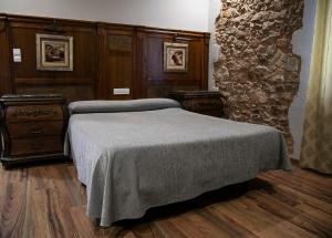 a bedroom with a bed and a stone wall at Hotel Restaurante Setos in Motilla del Palancar