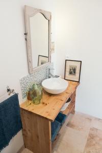 a bathroom with a sink and a mirror on a wooden counter at Le jardin du Castillon in Paradou