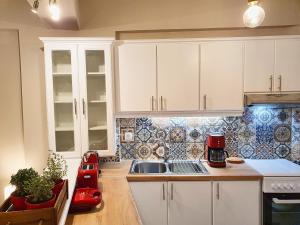 cocina con armarios blancos y licuadora roja en Gemareia Lodge en Lefkada