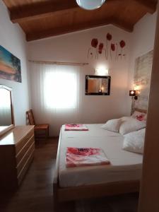 a bedroom with two beds and a mirror and a window at Apartments 2 Ivanković in Stari Grad