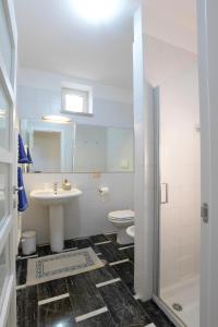 a white bathroom with a sink and a toilet at Bio&B Acquaviva in Otranto