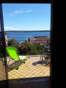 a view of a patio with a green chair and a table at Apartma Kočevar Portorož in Portorož