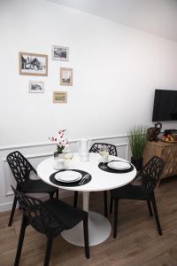 a dining room with a white table and chairs at Apartament Silva View in Hel