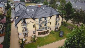 een groot huis met een zwart dak bij Willa Mirella in Dębki