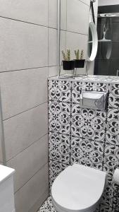 a bathroom with a toilet and a black and white tiles at ALEJA PARK CZĘSTOCHOWA in Częstochowa